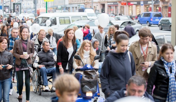 Процессия в инвалидных колясках и их сопровождающие занимают почти все пространство неширокого тротуара на Тверской