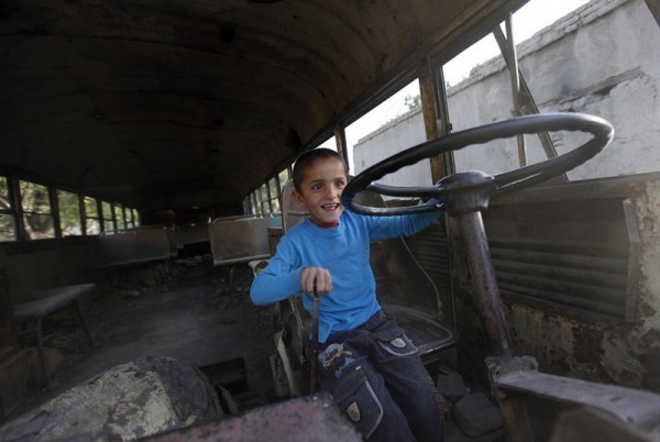 20.Афганский мальчик сидит за рулем развалившегося автобуса советских времен в Кабуле, 9 мая 2011 года. (AP Photo / Мустафа Курайши)