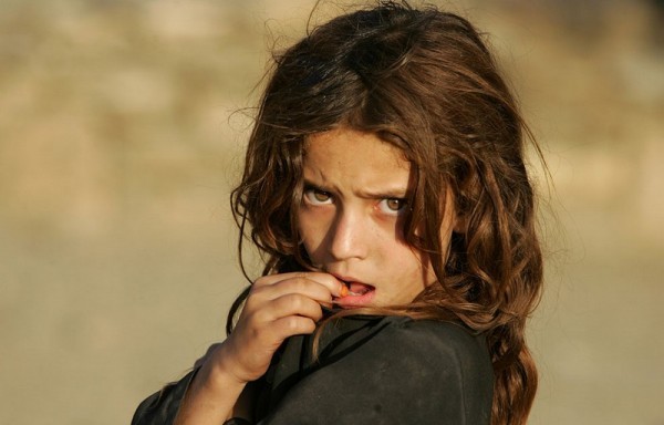 Девочка смотрит на американских солдат 1-го батальона 32 управления 10-й горной дивизии, патрулирующих рядом с базой Флорида в восточном Афганистане, 7 сентября 2006 года. (AP Photo / Саураб Дас)