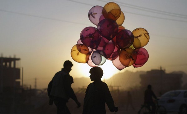 Магфуз Багбах, 12 лет, стоит у дороги, надеясь продать воздушные шарики на закате в Кабуле, 18 октября 2011 года. (AP Photo / Мухаммед Мухейзен)