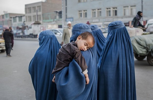 Маленький мальчик спит на плече женщины в Старом Городе, 7 ноября 2012 года в Кабуле. (Даниэль Берулак / Getty Images)