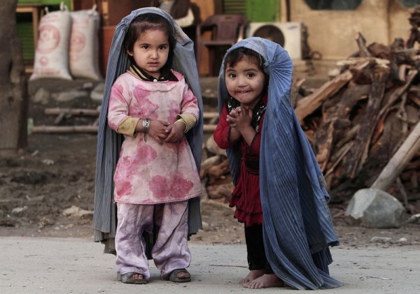 32.Две маленькие девочки играют в дом, подражая своим мамам, носящим паранджу. Паранджа подрезана под рост девочек. Пригород Джалалабада, восток Кабула, 17 марта 2013 года. (AP Photo / Рамат Гул)