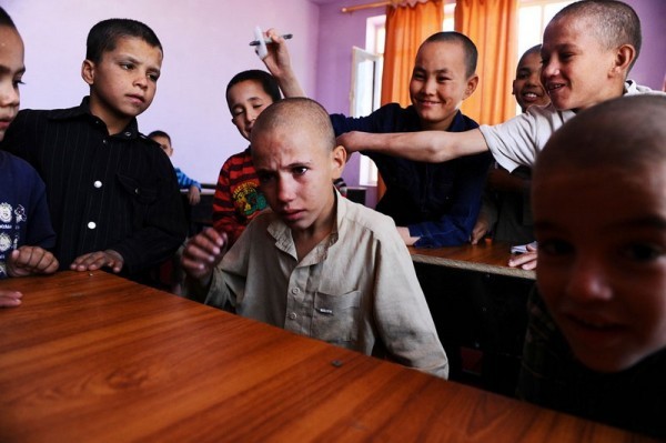 Афганский мальчик плачет, пока другие сироты дразнят его в классе приюта Балк на окраине города Мазар и Шариф, 7 октября 2012 года. 58 детей, преимущественно мальчиков, живут здесь. Их тут кормят, обучают и воспитывают при поддержке и по указаниям афганского правительства. (Кваис Усян / AFP / Getty Images)