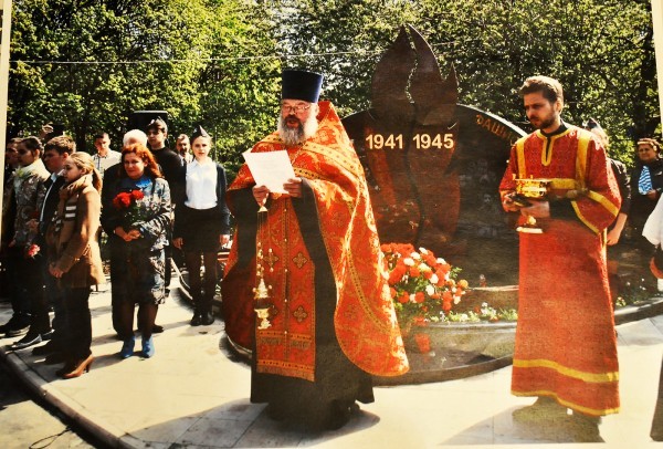 Священник освящает новый памятник