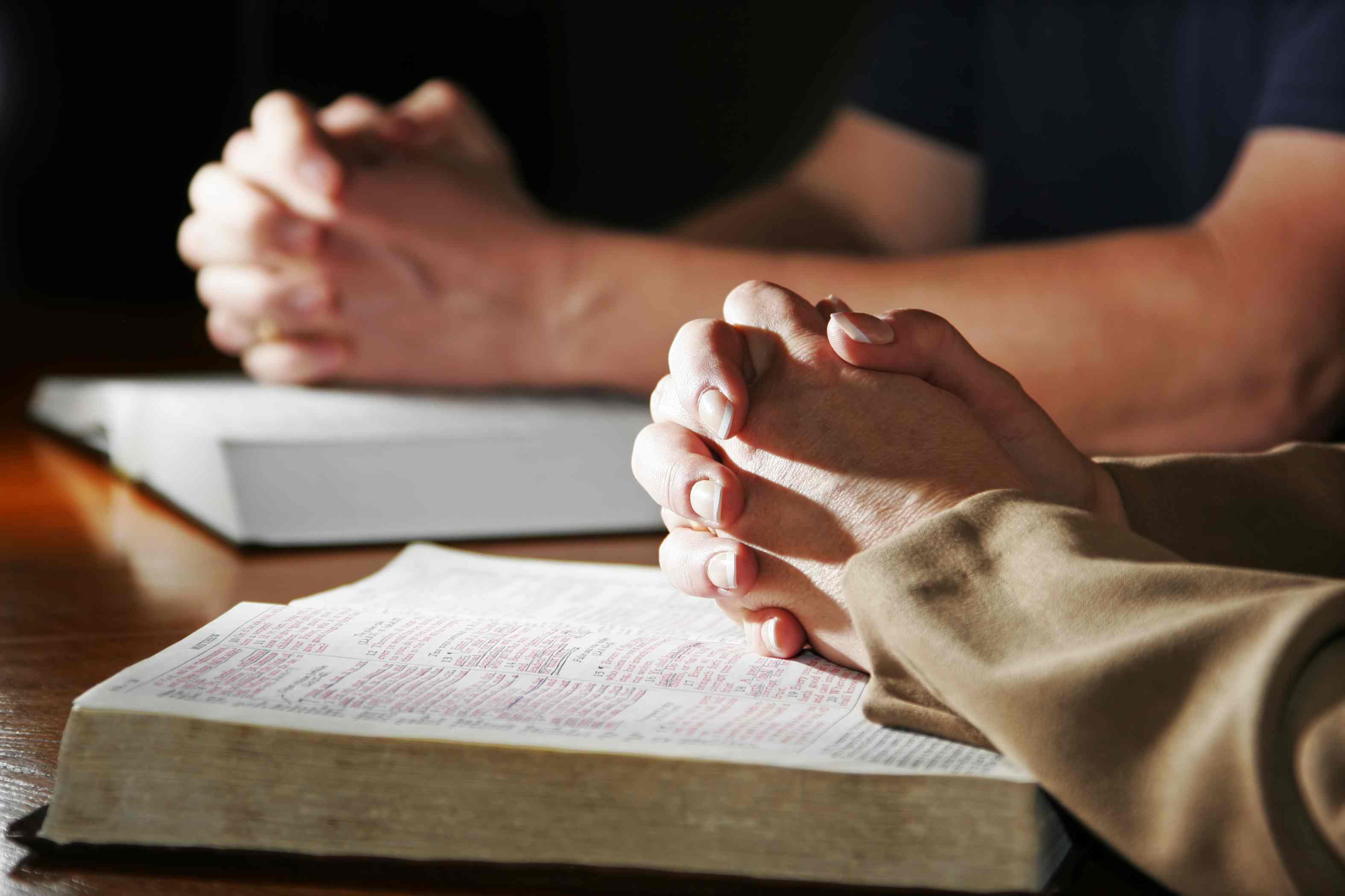 Библия и руки в молитве