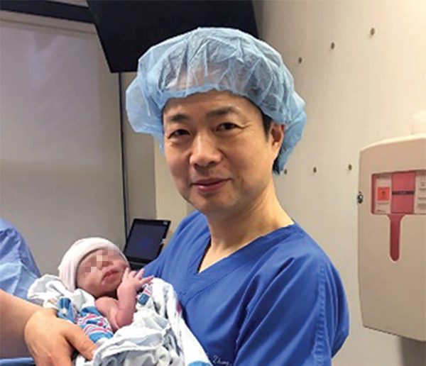 Доктор Джон Чжан с младенцем. Фото newscientist.com