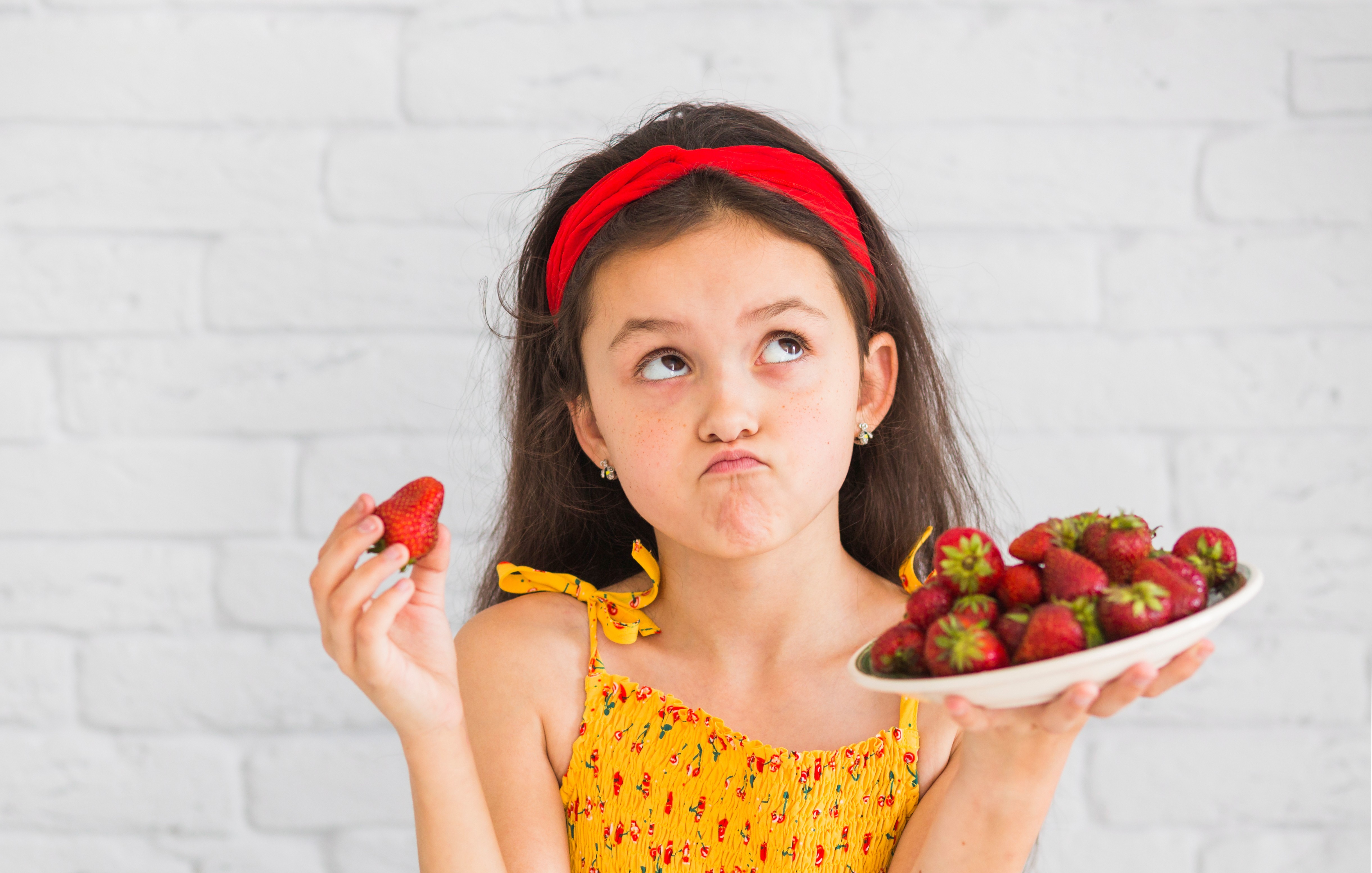Девочка держит тарелку с ягодой